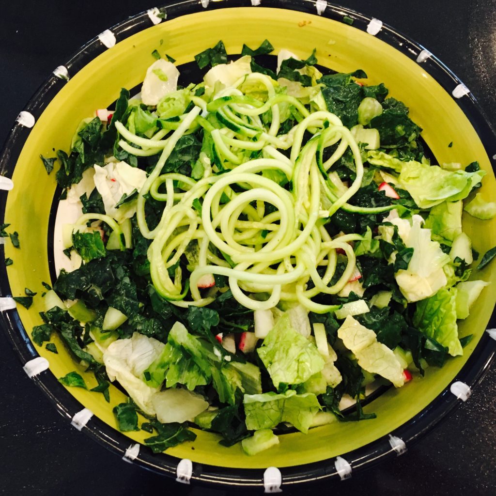 Green salad with zucchini noodle topping